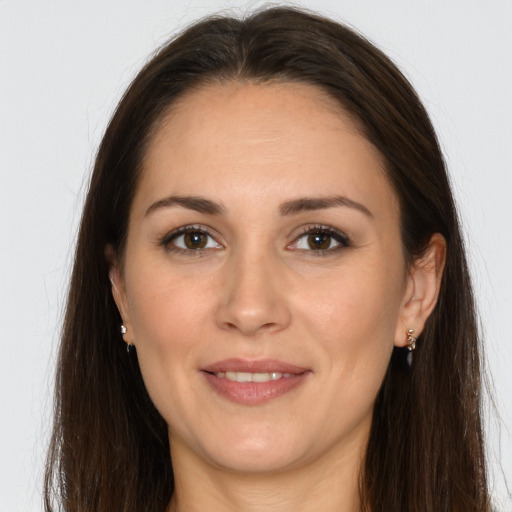 Joyful white adult female with long  brown hair and brown eyes