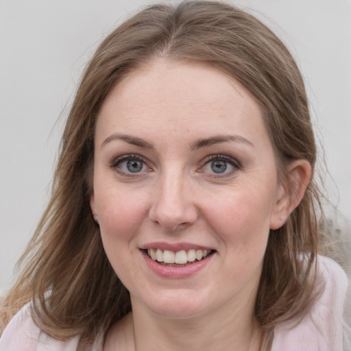 Joyful white young-adult female with medium  brown hair and blue eyes