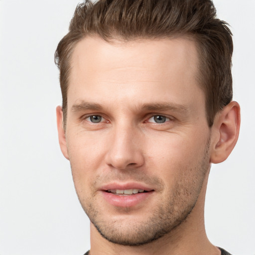 Joyful white young-adult male with short  brown hair and grey eyes