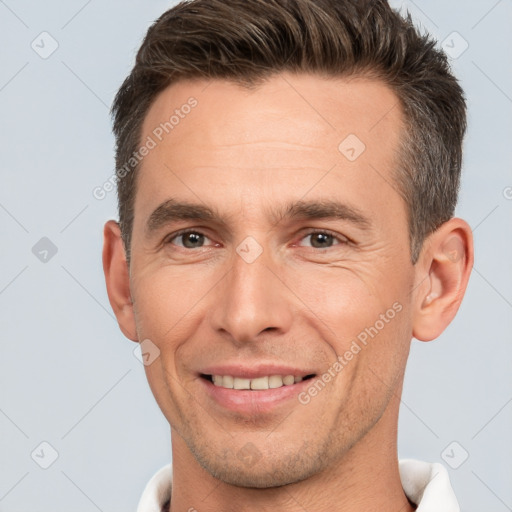 Joyful white adult male with short  brown hair and brown eyes