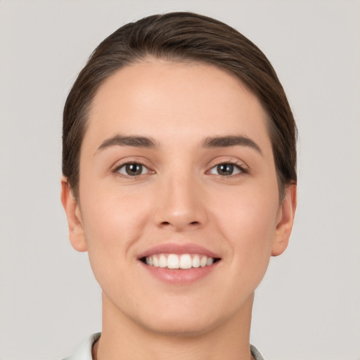 Joyful white young-adult female with short  brown hair and brown eyes