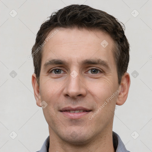 Joyful white young-adult male with short  brown hair and grey eyes