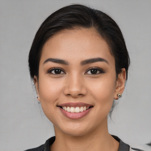 Joyful latino young-adult female with medium  brown hair and brown eyes