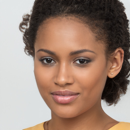 Joyful black young-adult female with long  brown hair and brown eyes