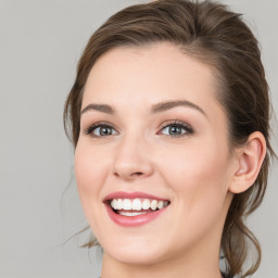 Joyful white young-adult female with medium  brown hair and blue eyes