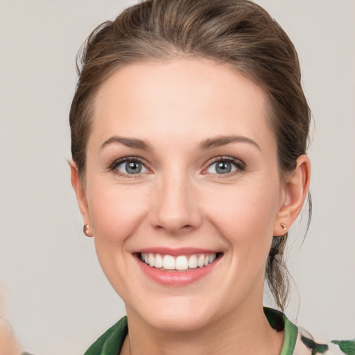 Joyful white young-adult female with medium  brown hair and green eyes