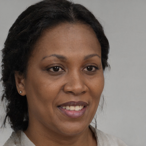 Joyful black adult female with medium  brown hair and brown eyes