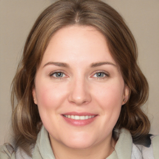 Joyful white young-adult female with medium  brown hair and blue eyes