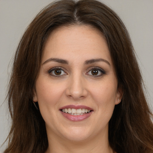 Joyful white young-adult female with long  brown hair and brown eyes