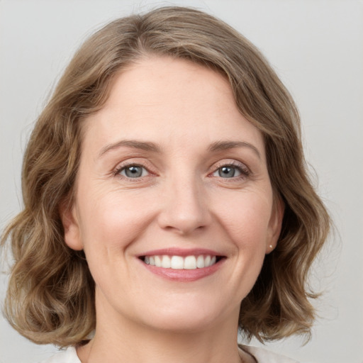 Joyful white young-adult female with medium  brown hair and green eyes