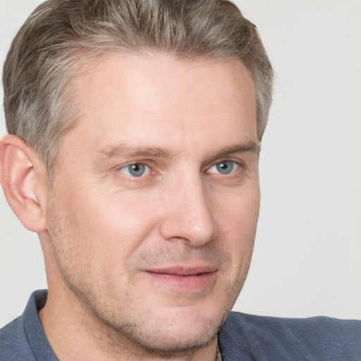 Joyful white adult male with short  brown hair and grey eyes