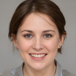 Joyful white young-adult female with medium  brown hair and grey eyes