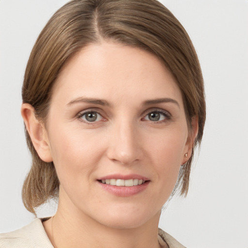 Joyful white young-adult female with medium  brown hair and grey eyes