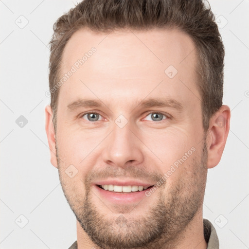 Joyful white young-adult male with short  brown hair and grey eyes