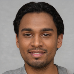 Joyful latino young-adult male with short  black hair and brown eyes