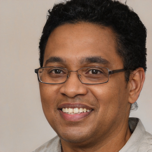 Joyful black adult male with short  brown hair and brown eyes