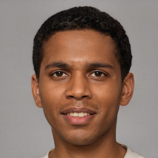 Joyful black young-adult male with short  black hair and brown eyes