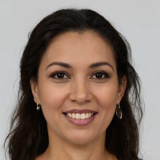 Joyful latino young-adult female with long  brown hair and brown eyes