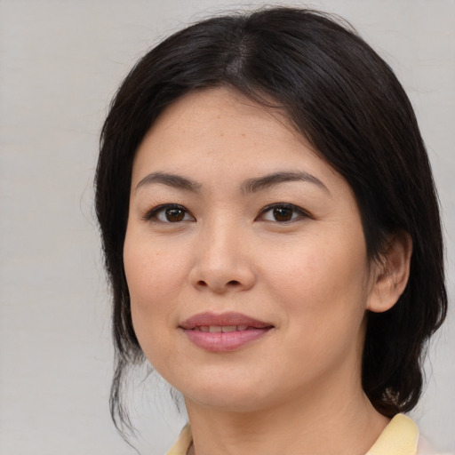 Joyful asian young-adult female with medium  brown hair and brown eyes