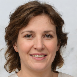 Joyful white adult female with medium  brown hair and grey eyes