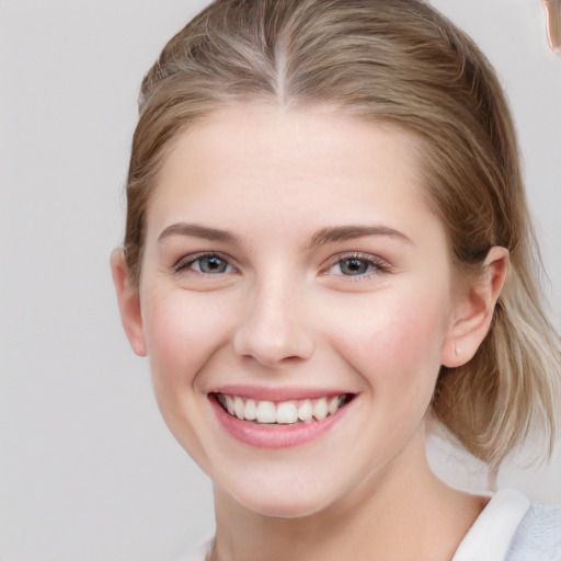 Joyful white young-adult female with medium  brown hair and blue eyes