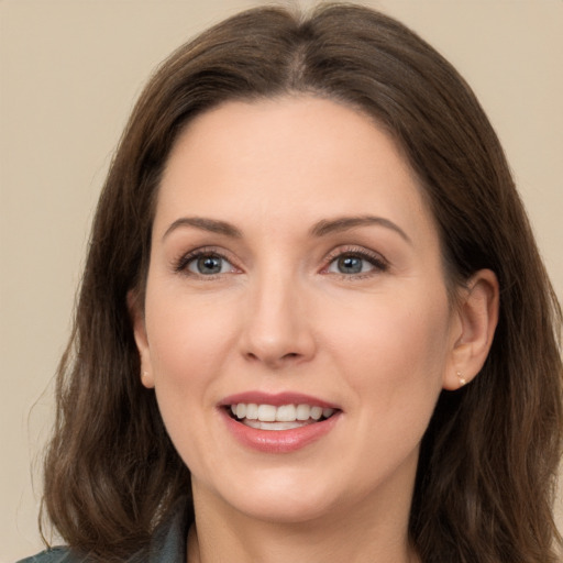 Joyful white young-adult female with long  brown hair and brown eyes