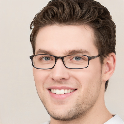 Joyful white young-adult male with short  brown hair and green eyes