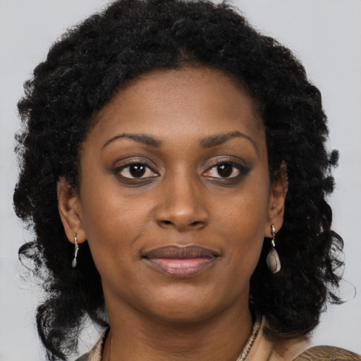 Joyful black young-adult female with long  brown hair and brown eyes