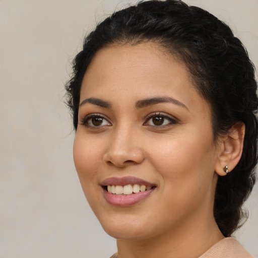 Joyful latino young-adult female with medium  brown hair and brown eyes