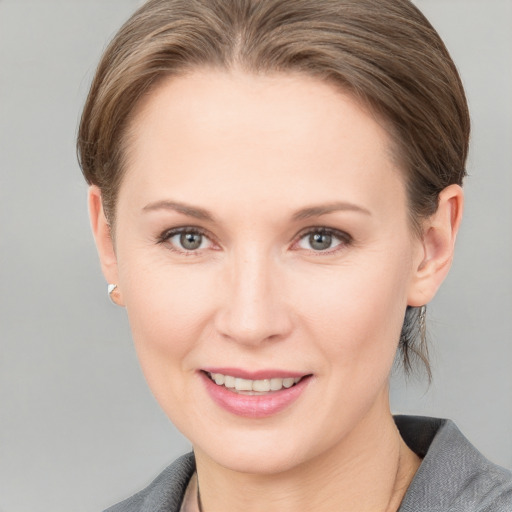 Joyful white young-adult female with medium  brown hair and grey eyes