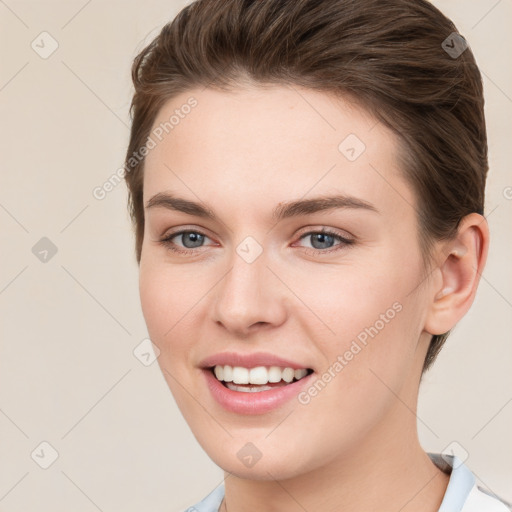 Joyful white young-adult female with short  brown hair and grey eyes