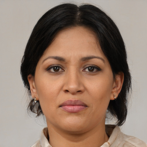Joyful latino adult female with medium  brown hair and brown eyes