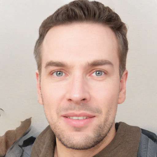 Joyful white young-adult male with short  brown hair and grey eyes