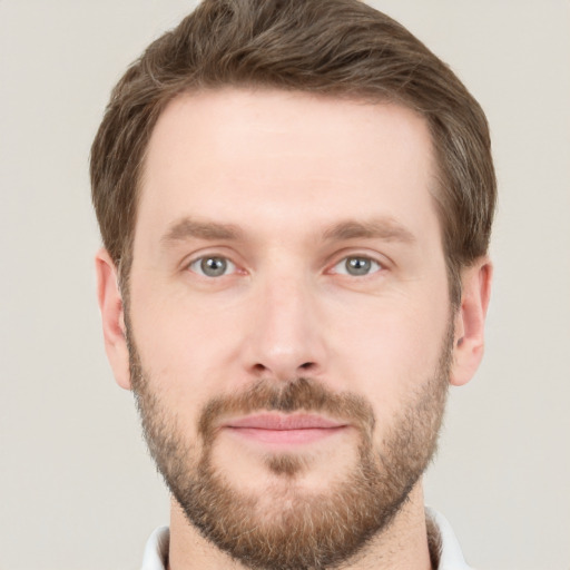 Joyful white young-adult male with short  brown hair and grey eyes