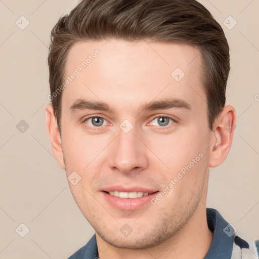 Joyful white young-adult male with short  brown hair and grey eyes