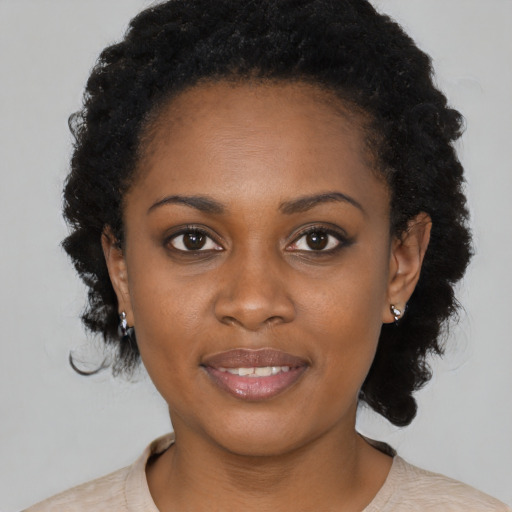 Joyful black young-adult female with short  brown hair and brown eyes