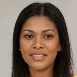 Joyful black young-adult female with long  brown hair and brown eyes