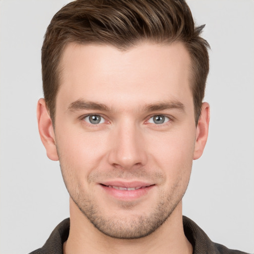 Joyful white young-adult male with short  brown hair and grey eyes