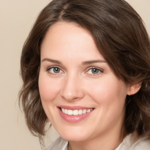 Joyful white young-adult female with medium  brown hair and green eyes