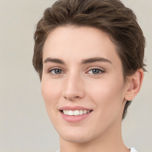 Joyful white young-adult female with short  brown hair and green eyes