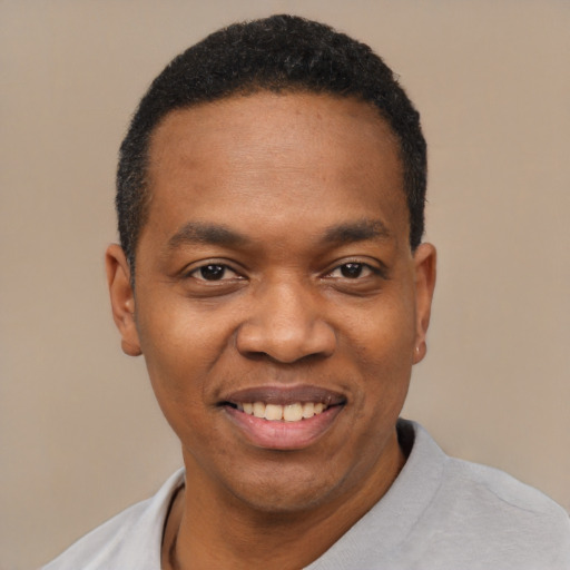 Joyful black young-adult male with short  black hair and brown eyes