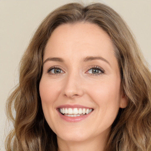 Joyful white young-adult female with long  brown hair and green eyes