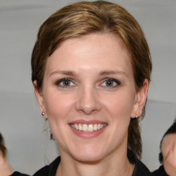 Joyful white young-adult female with medium  brown hair and blue eyes