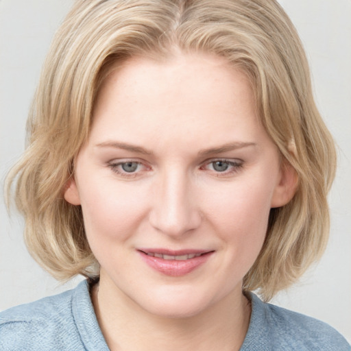 Joyful white young-adult female with medium  brown hair and blue eyes