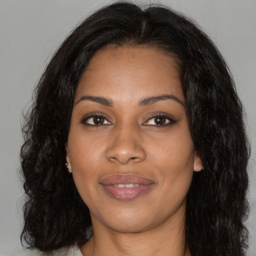 Joyful black young-adult female with long  brown hair and brown eyes