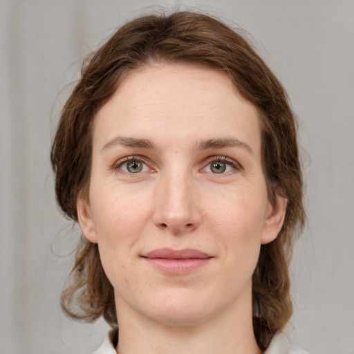 Joyful white young-adult female with medium  brown hair and green eyes