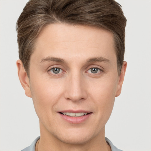 Joyful white young-adult male with short  brown hair and grey eyes