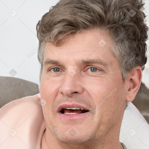 Joyful white adult male with short  brown hair and grey eyes