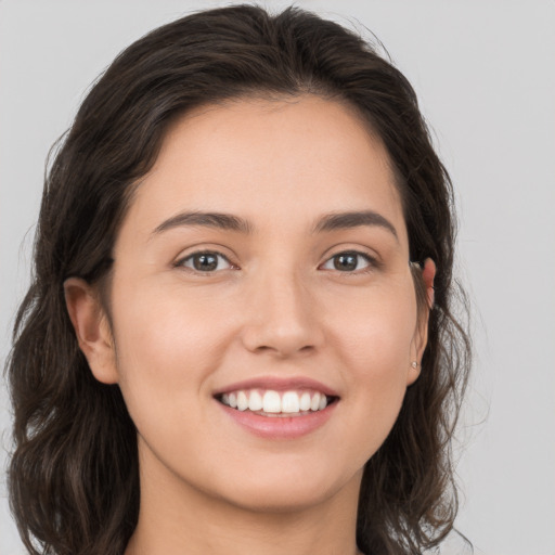 Joyful white young-adult female with long  brown hair and grey eyes