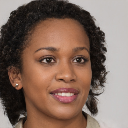 Joyful black young-adult female with medium  brown hair and brown eyes